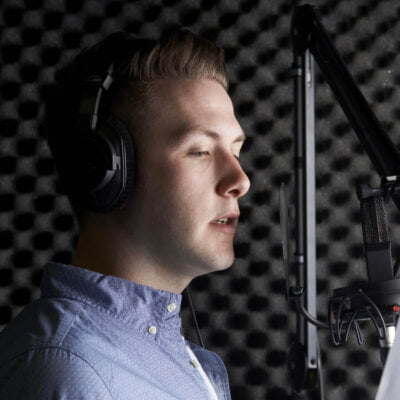 Man In Recording Studio Talking Into Microphone - Global Voice Acting Academy
